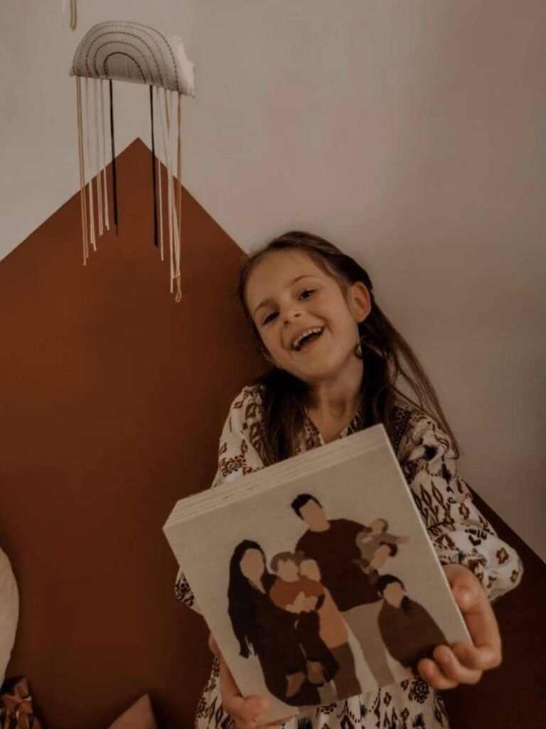 Manouk tekent Foto van meisje die een houten blok vast heeft met gezinsportret